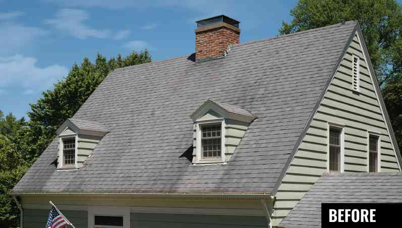 House with tan siding, two dormers with tan windows and ugly tan-grey roof with dark algae streaking.