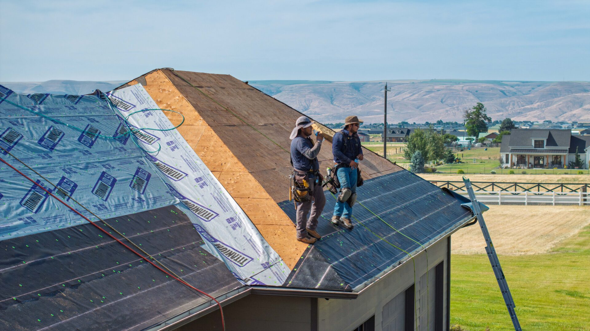 Two Russell Quality Roofing repairmen on a roof during a commercial roof repair job