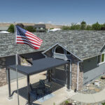 Side view shot of a blue colored roofing job completed by Russell Quality Roofing that is being inspected for hail damage