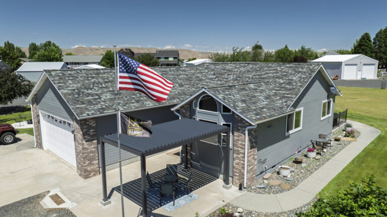 Side view shot of a blue colored roofing job completed by Russell Quality Roofing that is being inspected for hail damage