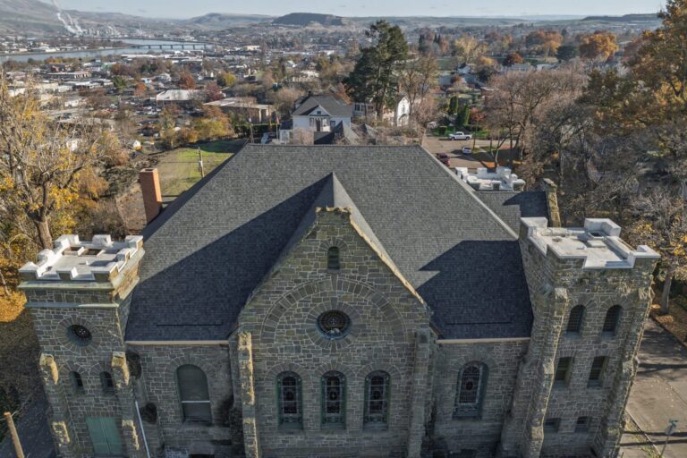 Drone shot of a completed commercial roofing project for a large stone building